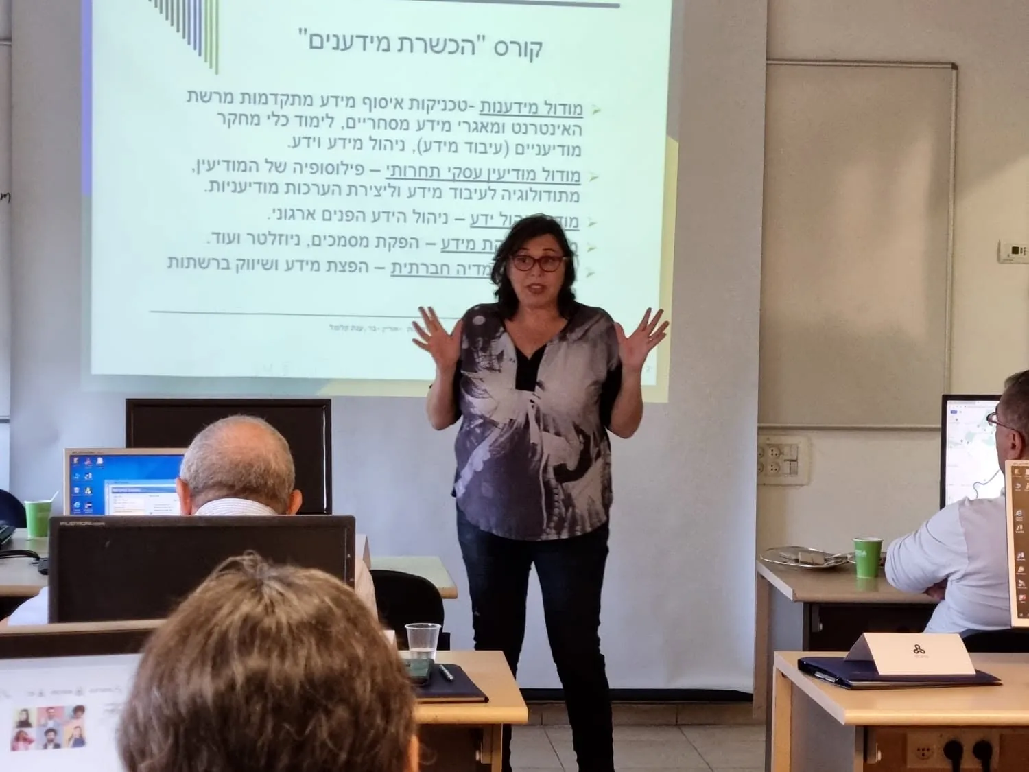 ד״ר ענת קלומל-פרוכצוייג מלמדת מידענות מול מצגת ולומדים בכיתת מחשבים