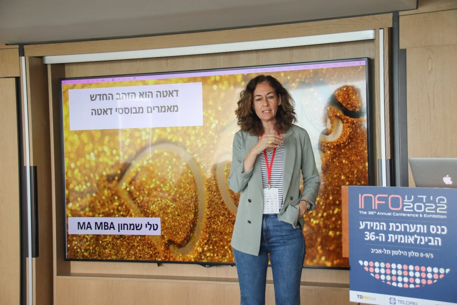 מרצה מציגה תובנות על דאטה בכנס מקצועי